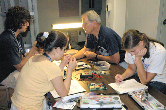 Paul Doupont helps with part identification as students check their parts kits against the lists.