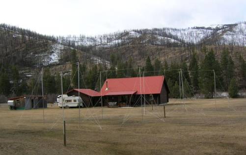 A view of several radio antennas on Dusty Samouce's property with large hills in the background