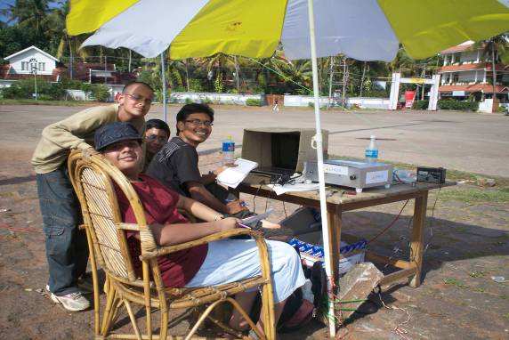 students sitting under an umbrella with the Radio JOVE equipment