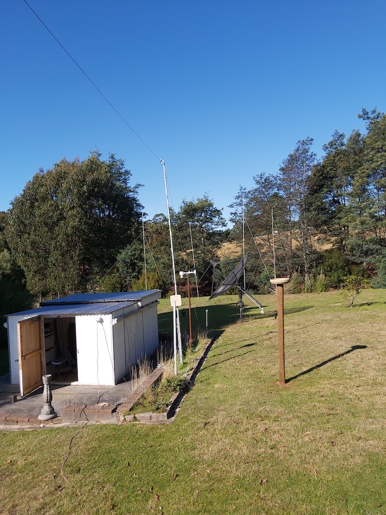 A photo of a small building with radio antennas above and behind it.